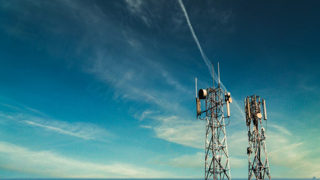 Cellular communications towers against blue sky background
