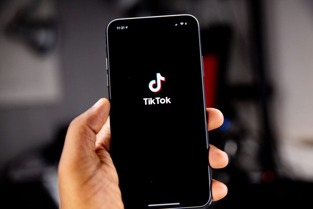 Person holding mobile phone with TikTok app logo