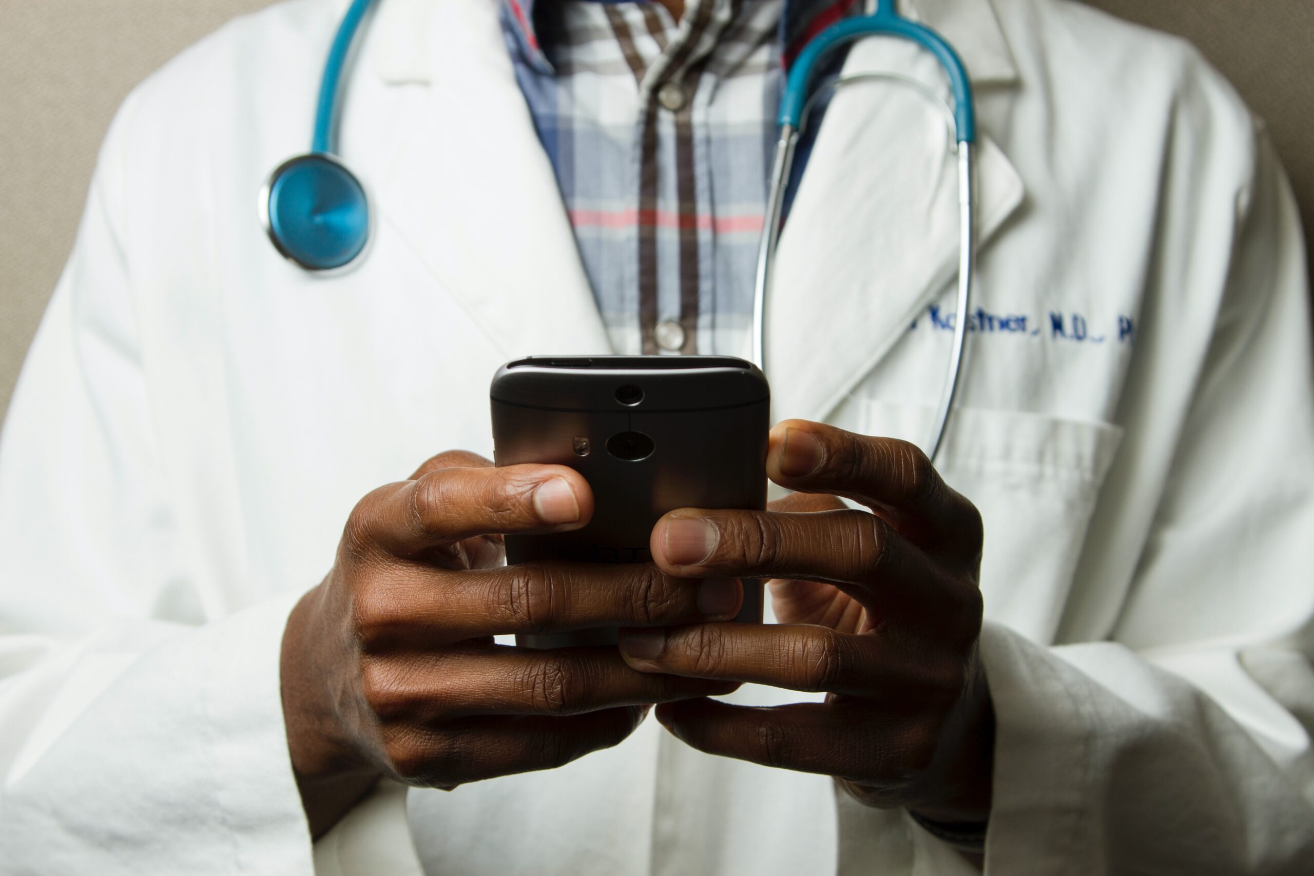 Doctor holding mobile phone in hands viewing patient data