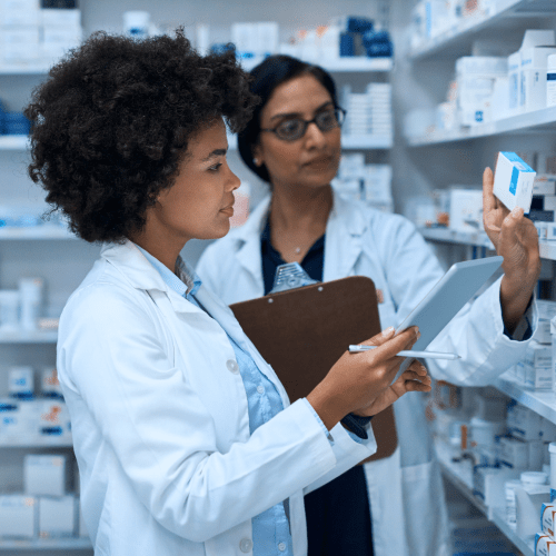Two women pharmacists inspecting drugs on shelf