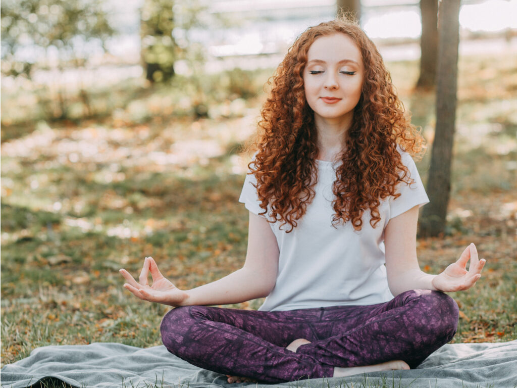 woman in outdoors performing peaceful meditation