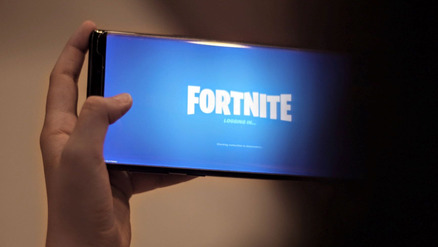 Person holding up mobile phone, playing Fortnite game